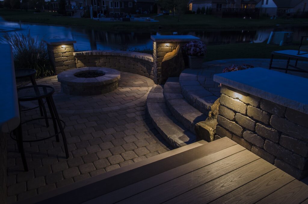 LED hardscape step lights under capstones around a patio and fire pit in St. Augustine, FL